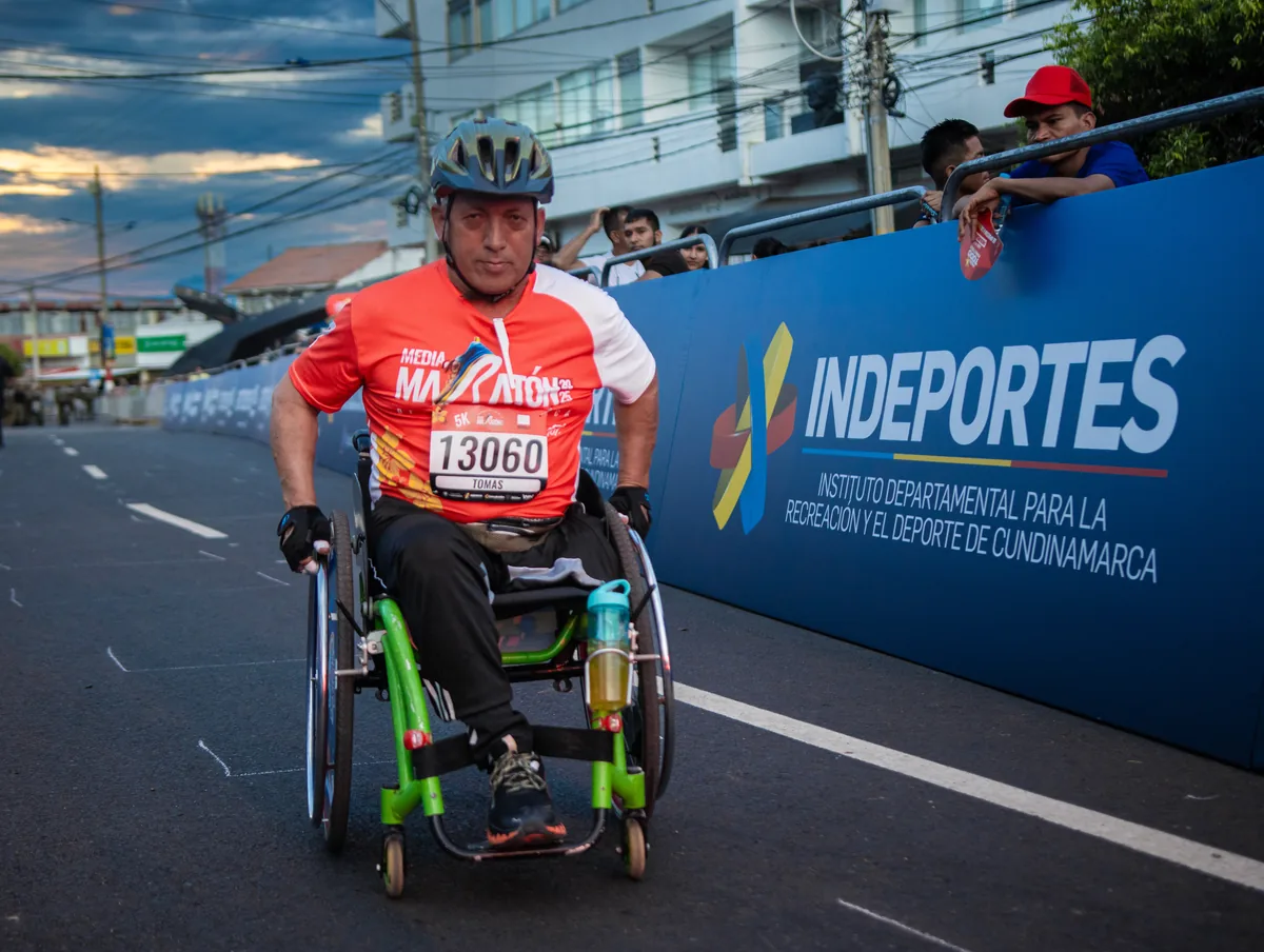 Un atleta en silla de ruedas de competencia avanzando hacia la cámara por la vía cerrada